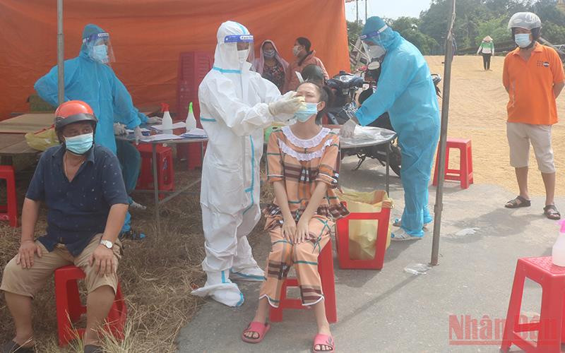 Nhân viên y tế xét nghiệm nhanh SARS-CoV-2 cho người dân. 