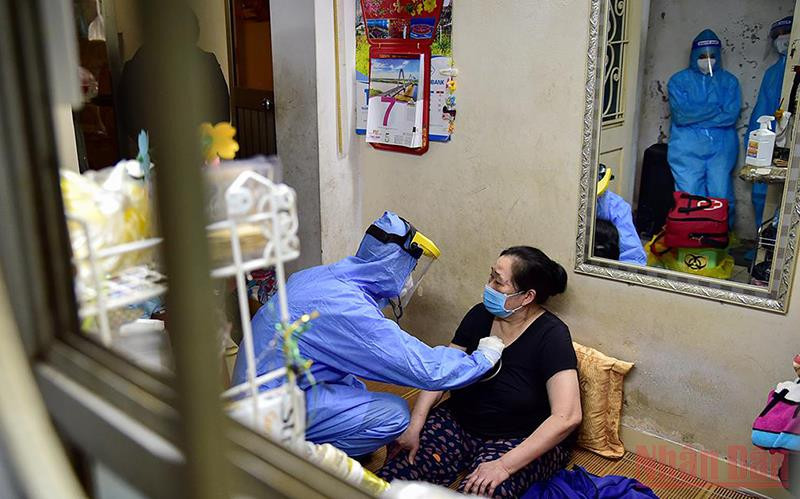 Nhân viên y tế khám sàng lọc trước khi tiêm chủng cho người dân tại nhà. (Ảnh: THÀNH ĐẠT)