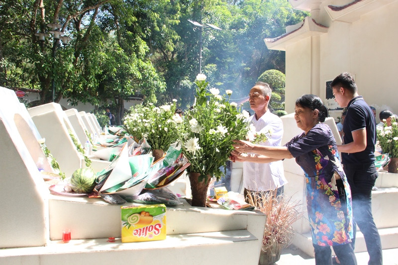 Anh hùng LLVTND La Thị Tám và Anh hùng LLVTND Nguyễn Xuân Lứ bên mộ các đồng đội. 