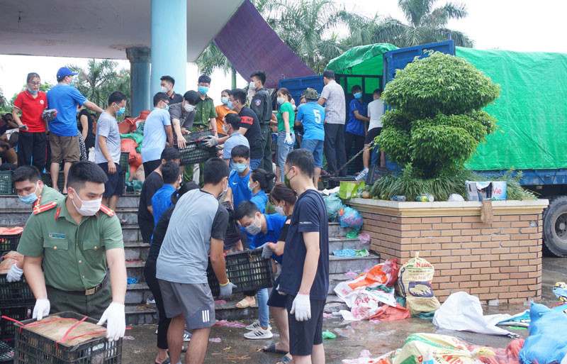 Đông đảo cán bộ, nhân dân đến hỗ trợ phân loại, bốc xếp hàng hóa. 