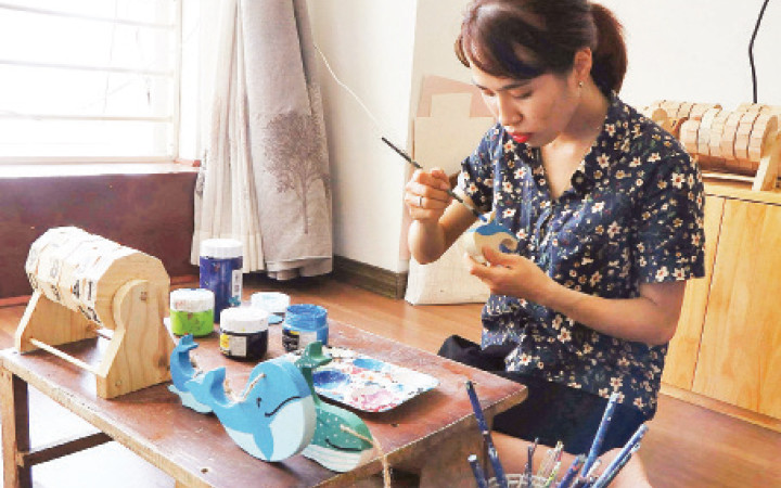 Cô gái trẻ Nguyễn Thị Hảo đang làm các sản phẩm đồ chơi cho trẻ em từ những mẩu gỗ thừa.