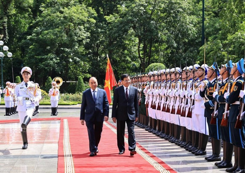 Chủ tịch nước Nguyễn Xuân Phúc và Tổng Bí thư Ban Chấp hành Trung ương Đảng Nhân dân Cách mạng Lào, Chủ tịch nước Cộng hòa Dân chủ Nhân dân Lào Thongloun Sisoulith duyệt Đội danh dự Quân dội nhân dân Việt Nam. (Ảnh: TTXVN)