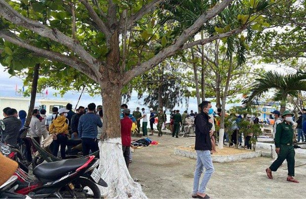 Người dân theo dõi lực lượng chức năng tìm kiếm nạn nhân mất tích. (Nguồn: Zing)