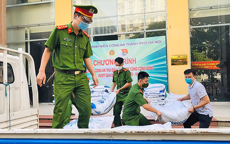 Cán bộ, chiến sĩ trẻ của lực lượng công an Thủ đô vận chuyển lương thực, nhu yếu phẩm từ nơi tập kết đến các khu dân cư.