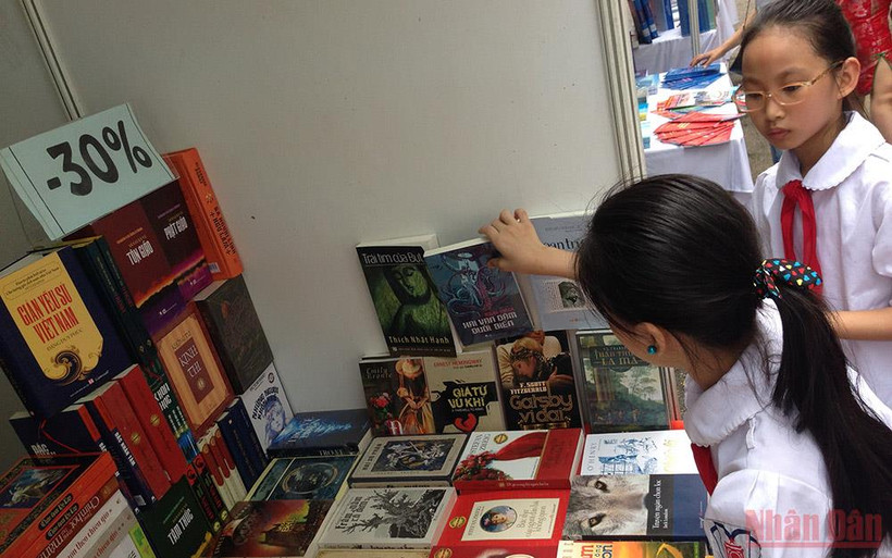 Xây dựng văn hóa đọc sâu rễ bền gốc từ lứa tuổi nhỏ là nhiệm vụ quan trọng. (Ảnh: Các em học sinh tham khảo sách tại khu trưng bày nhân Ngày Sách Việt Nam của Thư viện Quốc gia)