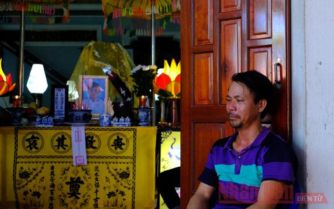 Ông Đặng Minh Vương thẫn thờ bên di ảnh của con là cháu Đặng Minh Nhật.