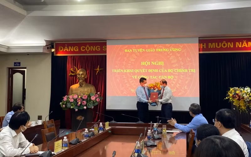 Đồng chí Nguyễn Trọng Nghĩa trao quyết định và tặng hoa, chúc mừng đồng chí Lê Hải Bình.