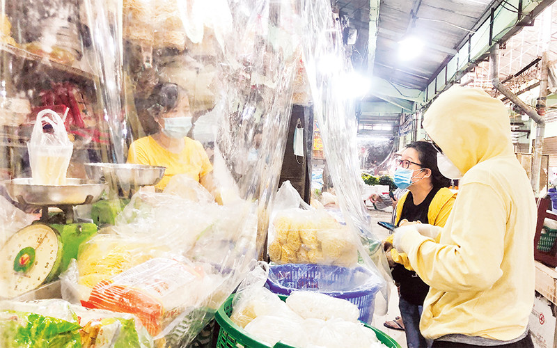 Tiểu thương ở chợ Nguyễn Tri Phương (quận 10) lắp vách ngăn để hạn chế tiếp xúc trực tiếp.