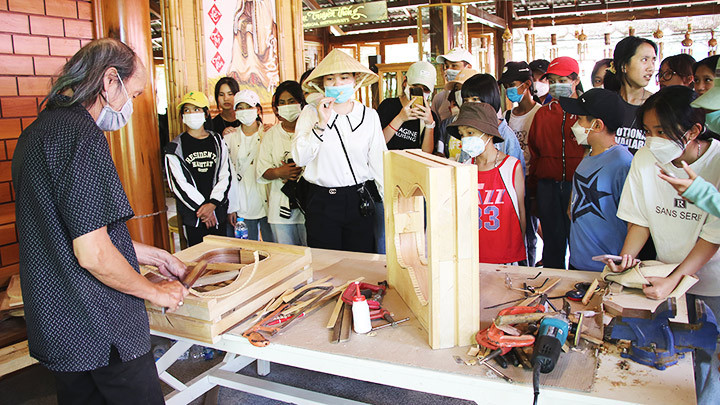 Du khách tham quan xưởng của nghệ nhân Lưu Hoàng Quý.