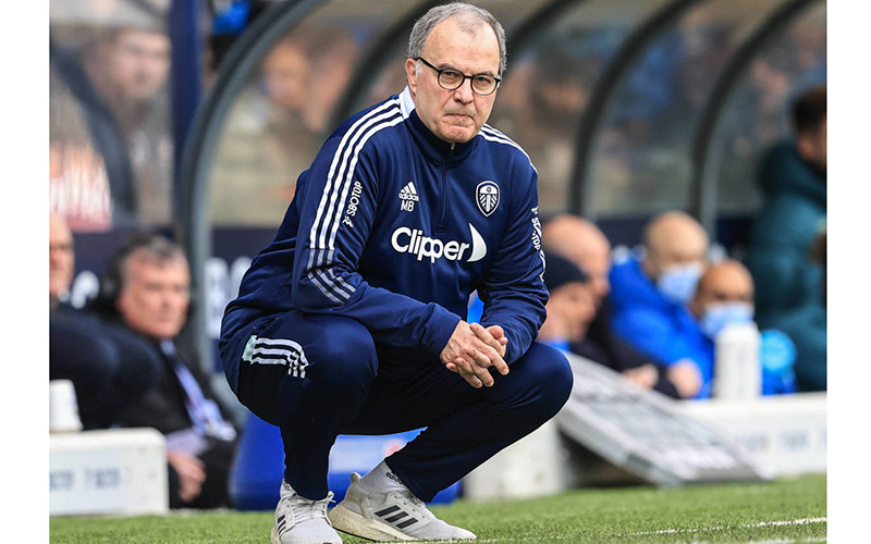 Marcelo Bielsa và dáng ngồi đặc trưng trên đường pitch. (Ảnh: SportIllustrated)