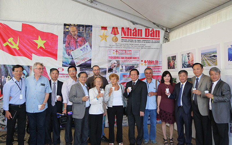 Tác giả (thứ năm từ trái sang) và một số Việt kiều vinh dự chụp ảnh cùng Đoàn đại biểu Báo Nhân Dân do Phó Tổng Biên tập Phan Huy Hiền dẫn đầu và các bạn Pháp gắn bó với Việt Nam tại Gian trưng bày Báo Nhân Dân ở Hội báo Nhân đạo tháng 9-2016. 