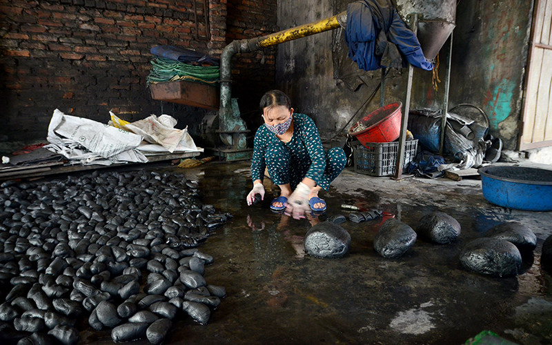 Bà Ðào Thị Nở cắt các cục nến to thành những cục nến nhỏ để chuẩn bị cho công đoạn se hương.