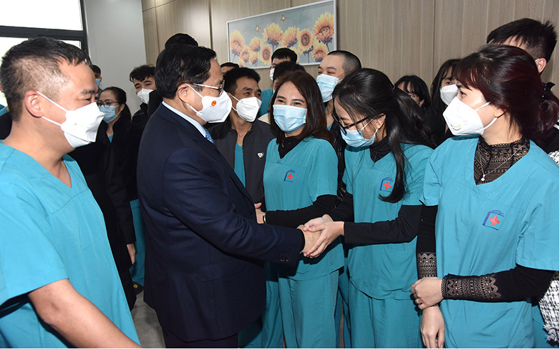 Thủ tướng Phạm Minh Chính tới thăm, chúc Tết đội ngũ bác sĩ, y tá, nhân viên y tế đang làm nhiệm vụ tại Bệnh viện điều trị bệnh nhân Covid-19 của Bệnh viện Đại học Y Hà Nội, đặt tại quận Hoàng Mai.