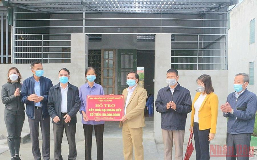 Đại diện lãnh đạo Ủy ban Mặt trận Tổ quốc tỉnh Hà Nam trao tiền hỗ trợ xây nhà "Đại đoàn kết" cho gia đình bà Đinh Thị Trụ. (Ảnh: ĐÀO PHƯƠNG) 
