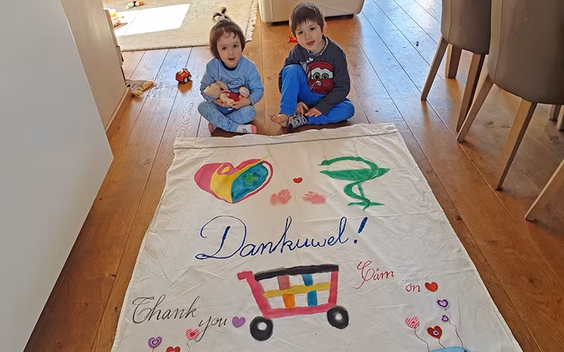 Các con của chị Thanh cùng mẹ làm băng-rôn bằng ba thứ tiếng Hà Lan - Việt Nam - Anh, cảm ơn những người đang ngày đêm nỗ lực cứu chữa bệnh nhân, phục vụ cộng đồng.