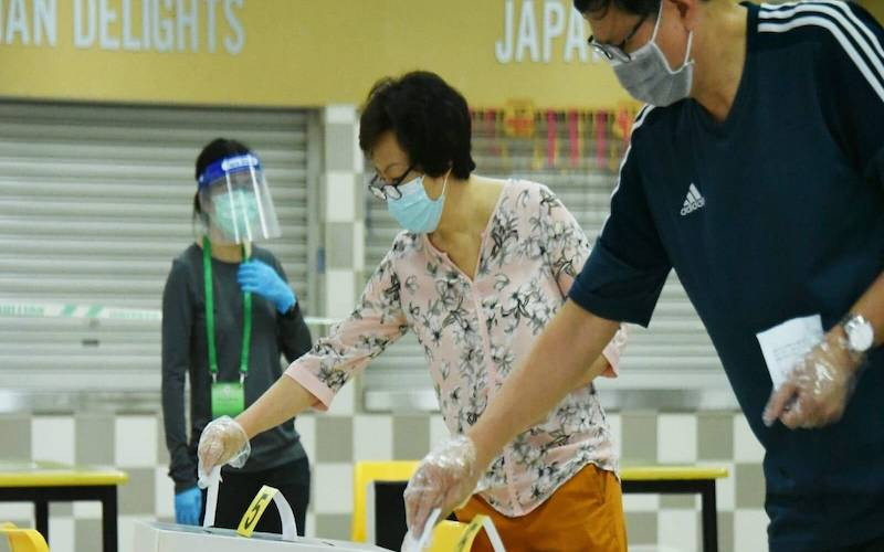 Cử tri Singapore đeo khẩu trang và găng tay bỏ phiếu tại Trường trung học Chung Cheng, ngày 10-7-2020. (Ảnh: Channel News Asia)