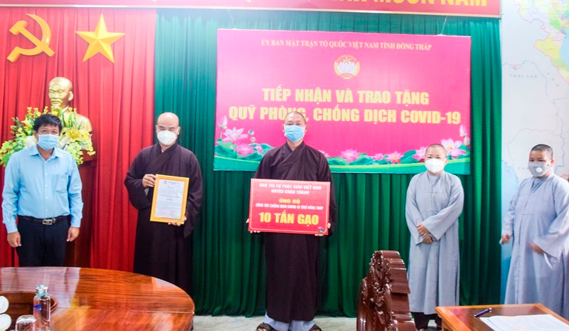 Đại diện Ban Trị sự Phật giáo Việt Nam huyện Châu Thành trao tặng bảng tượng trưng 10 tấn gạo.