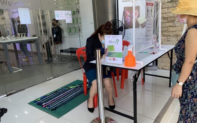 Khách hàng phải chứng minh đã tiêm đủ mũi vaccine phòng Covid-19 mới được vào sử dụng dịch vụ tại một cửa hàng ở Thủ đô Vientiane. (Ảnh: Xuân Sơn)