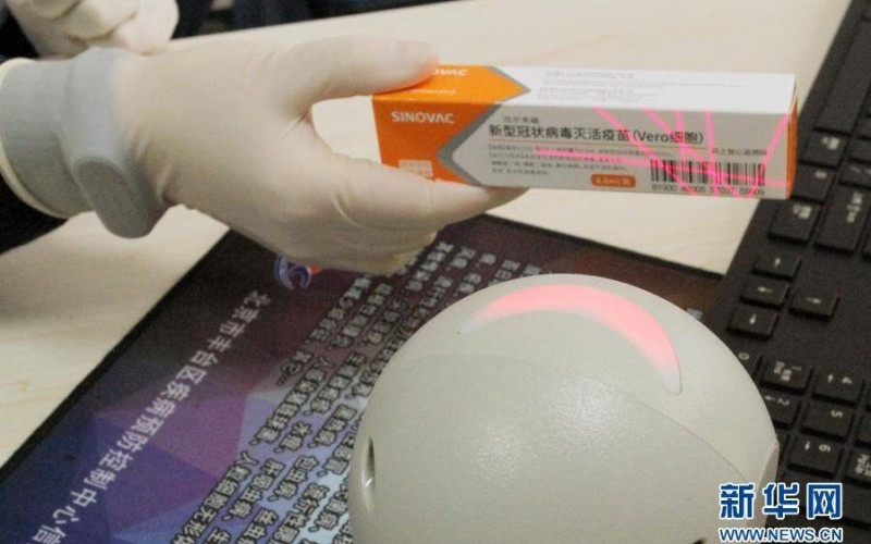 Nhân viên y tế quét mã vạch hộp vaccine phòng, chống Covid-19, chuẩn bị tiêm chủng. (Ảnh: Tân Hoa xã)