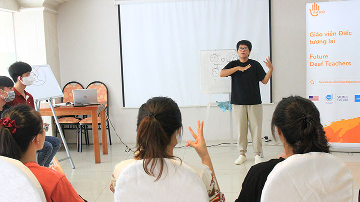 Thủy Tiên (đứng) tham gia tập huấn trong một chương trình dành cho người điếc.