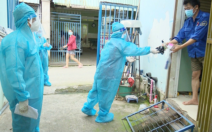 Cán bộ trạm y tế lưu động phát thuốc cho bệnh nhân Covid-19 tại thị xã Tân Uyên, tỉnh Bình Dương. Ảnh: ĐỖ TRỌNG