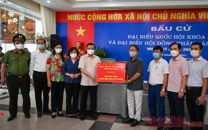 Bí thư Thành uỷ Đinh Tiến Dũng tặng quà hỗ trợ công tác phòng, chống dịch Covid-19 cho Tổ bầu cử số 8, phường Phú Thượng, quận Tây Hồ. (Ảnh: Duy Linh)