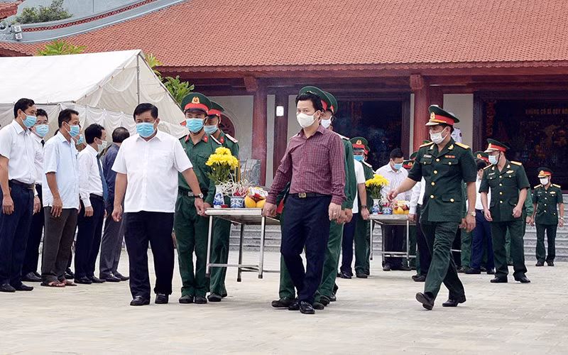 Đồng chí Nguyễn Chí Dũng, Bộ trưởng Kế hoạch và đầu tư và đồng chí Đặng Quốc Khánh, Bí thư Tỉnh ủy tỉnh Hà Giang tiễn đưa linh cữu các Anh hùng liệt sĩ về nơi yên nghỉ cuối cùng. (Ảnh: baohagiang.vn)