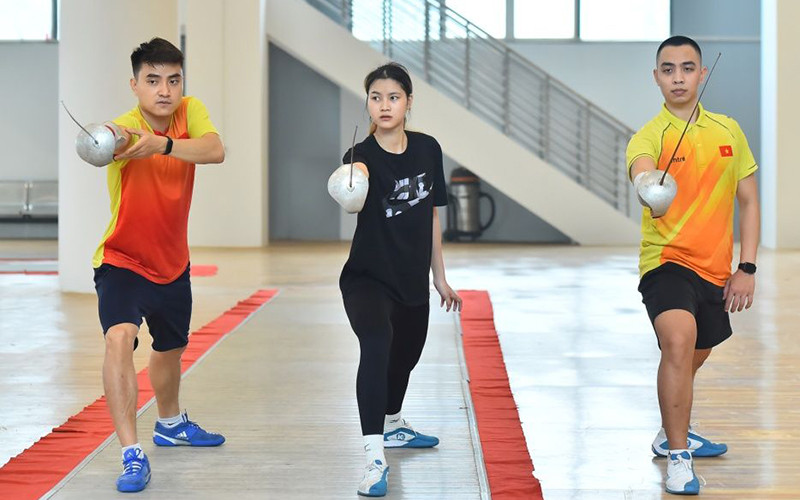 Vận động viên Hà Thanh An (người bên trái) hướng dẫn đồng đội nội dung kiếm chém chuẩn bị cho SEA Games 31. (Ảnh Mỹ Hà)