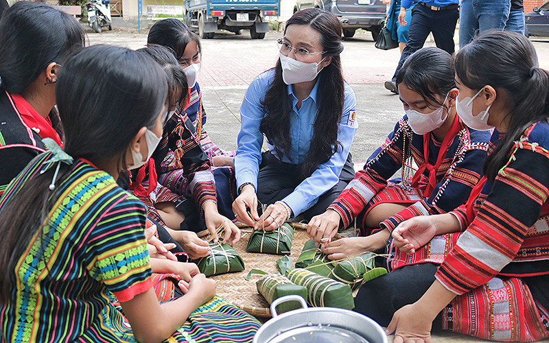 Đồng chí Nguyễn Phạm Duy Trang cùng thiếu nhi dân tộc thiểu số gói bánh chưng, bánh tét tại chương trình “Xuân sẻ chia-Tết yêu thương”.