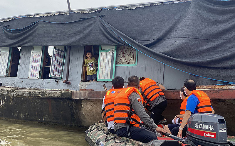 Các thành viên đoàn tình nguyện tiếp cận một gia đình sống trên sông Hồng.