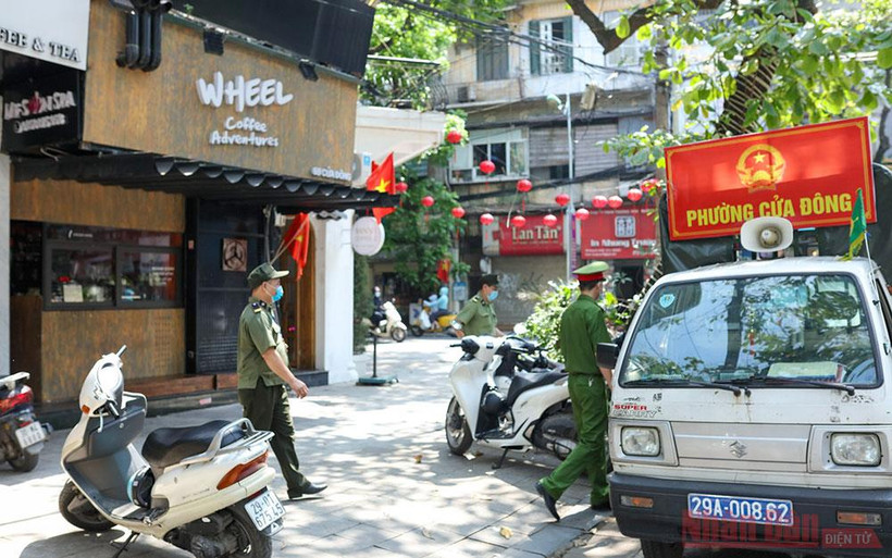 Công an phường Cửa Đông tuyên truyền nhắc nhở người dân phòng chống dịch. Ảnh: DUY LINH