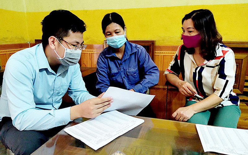 Cán bộ Bảo hiểm xã hội tỉnh Yên Bái hướng dẫn người lao động cài đặt ứng dụng VssID. Ảnh: HỒNG DUYÊN 