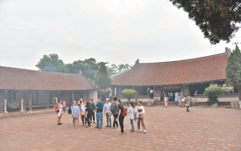 Du khách tham quan đình Mông Phụ tại làng Đường Lâm, thị xã Sơn Tây. (Ảnh Duy Đăng)