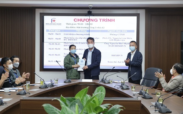 Tổng Giám đốc Bảo hiểm xã hội Việt Nam Nguyễn Thế Mạnh tặng quà người nhà bệnh nhân đặc biệt khó khăn tại Bệnh viện Đại học Y Hà Nội. (Ảnh: VSS)