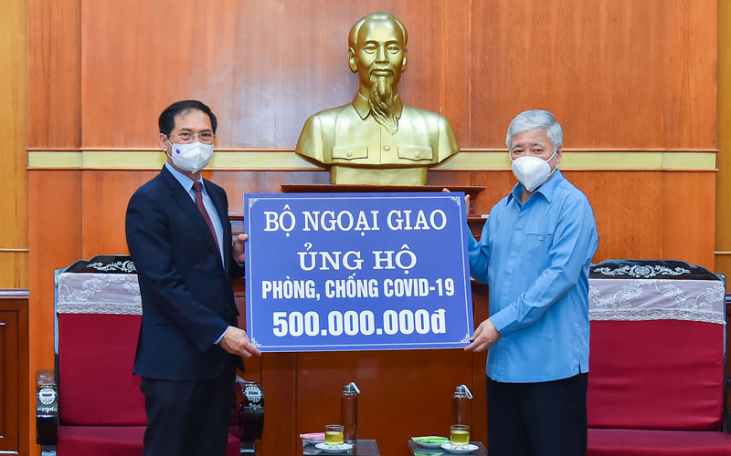 Bộ trưởng Ngoại giao Bùi Thanh Sơn trao tượng trưng số tiền 500 triệu đồng tới Bí thư Trung ương Đảng, Chủ tịch Ủy ban Trung ương Mặt trận Tổ quốc Việt Nam Đỗ Văn Chiến. (Ảnh: MOFA)