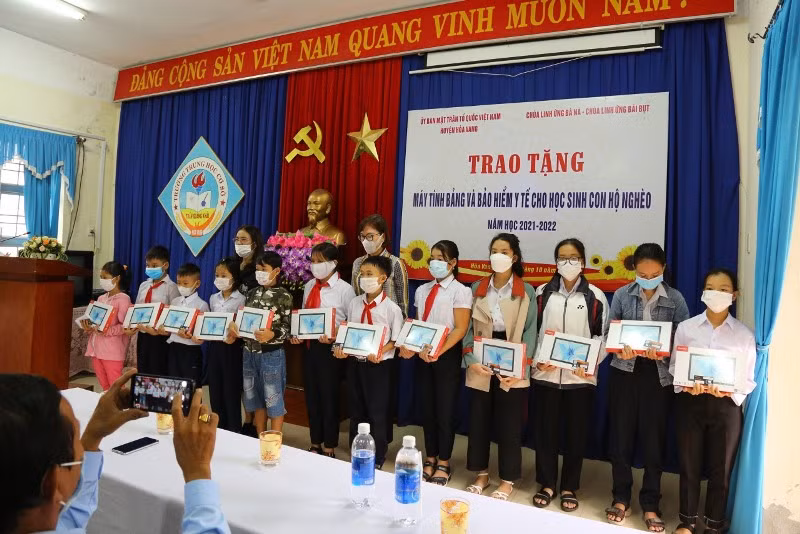 Trao máy tính bảng cho học sinh.