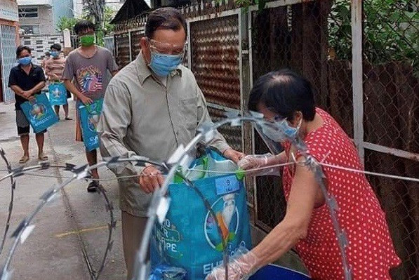 Người dân ở quận 12 nhận nhu yếu phẩm hỗ trợ của chính quyền địa phương.