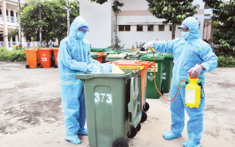 Công nhân Công ty Môi trường đô thị tiến hành khử khuẩn rác thải y tế liên quan dịch Covid-19.