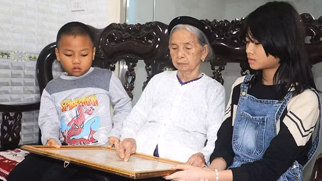 Cụ Phạm Thị Mong nâng niu tấm bằng Tổ quốc ghi công của người con liệt sĩ.