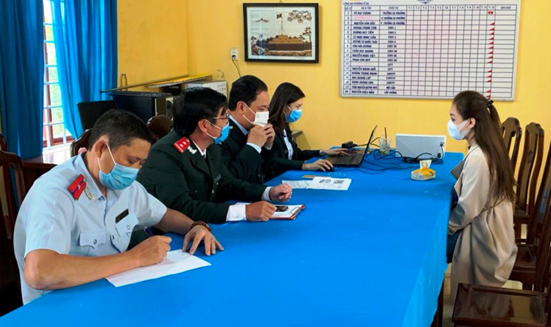 Cơ quan chức năng làm việc với chủ tài khoản mạng xã hội sai phạm (bên phải).