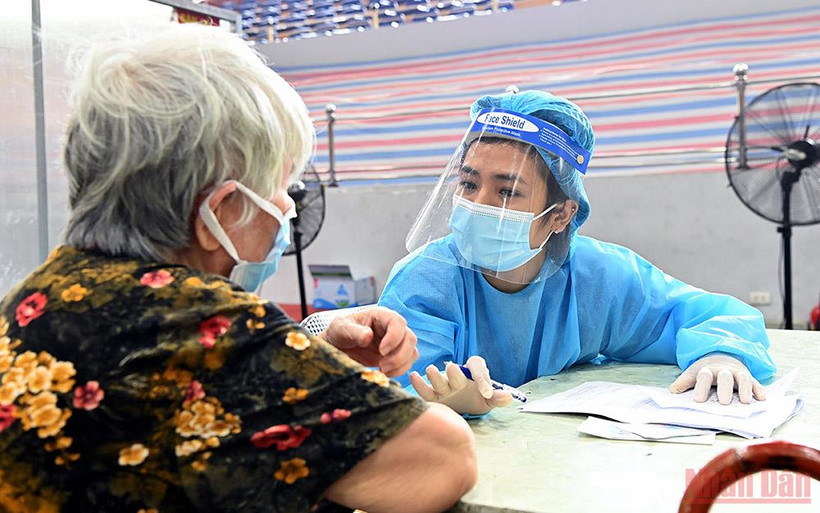 Nhập thông tin trước khi tiêm cho người cao tuổi ở Hà Nội. (Ảnh: DUY LINH)