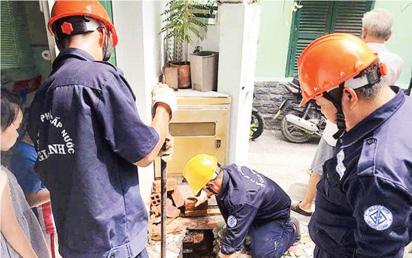 Công nhân Công ty cổ phần cấp nước Gia Định hỗ trợ người dân trám lấp giếng khoan gia đình trên địa bàn quận Gò Vấp.
