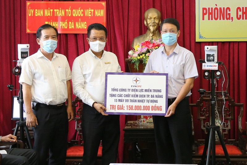 Tổng Giám đốc EVNCPC Ngô Tấn Cư (bên trái) trao bảng tượng trưng kinh phí hỗ trợ mua vaccine và 15 máy đo thân nhiệt tự động.