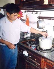 Kỹ sư Phương đang nấu bếp dầu đun theo kiểu gas.