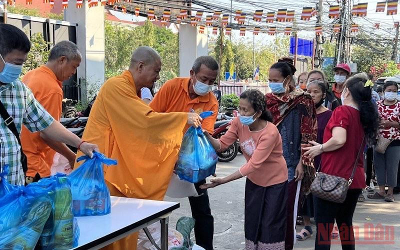 Thượng tọa Thích Minh Quang (thứ 3 từ trái qua) trao hỗ trợ kiều bào nghèo ở Thủ đô Vientiane trong lễ Thượng nguyên 2022. (ẢNH: XUÂN SƠN)