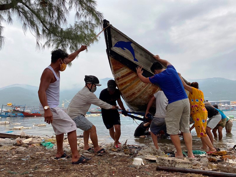 Lực lượng chức năng giúp người dân kéo tàu thuyền vào bờ, tránh bão số 5, sáng ngày 17-9.