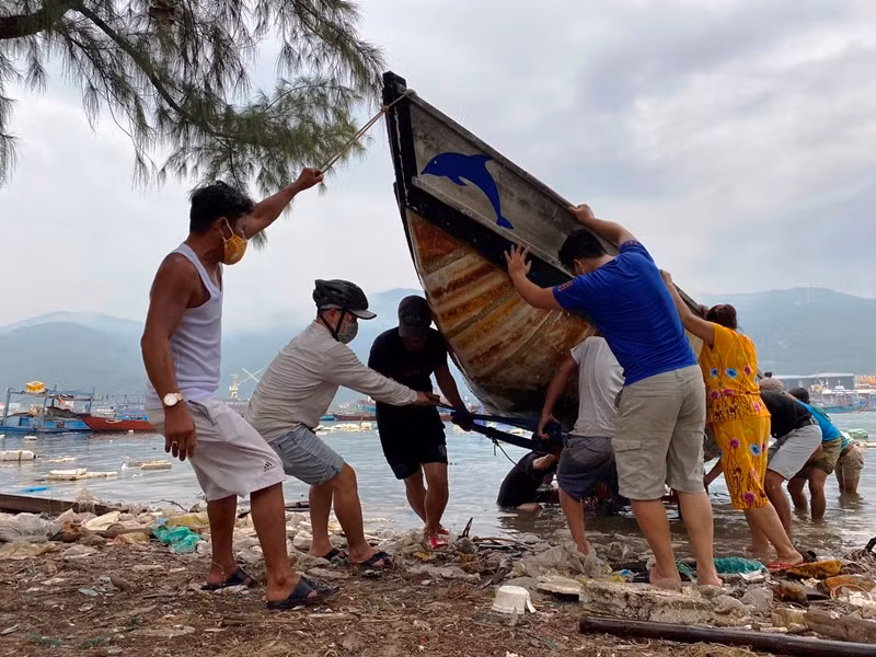Lực lượng chức năng giúp người dân kéo tàu thuyền vào bờ, tránh bão số 5, sáng ngày 17-9.