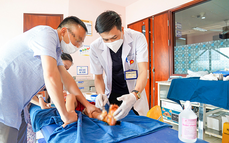 Bác sĩ xử trí vết thương cho bé bị tai nạn cửa trượt tự động. 