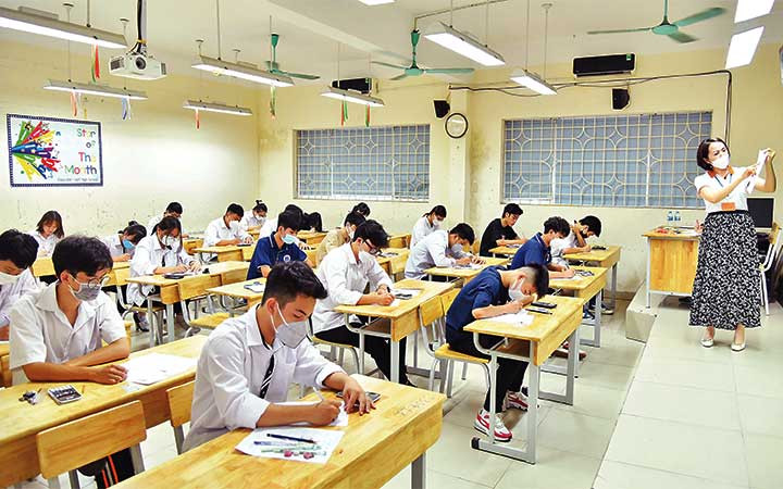 Giám thị hướng dẫn cách làm bài thi môn Toán tại điểm thi Trường THPT Nguyễn Gia Thiều, thành phố Hà Nội. (Ảnh: MỸ HÀ)