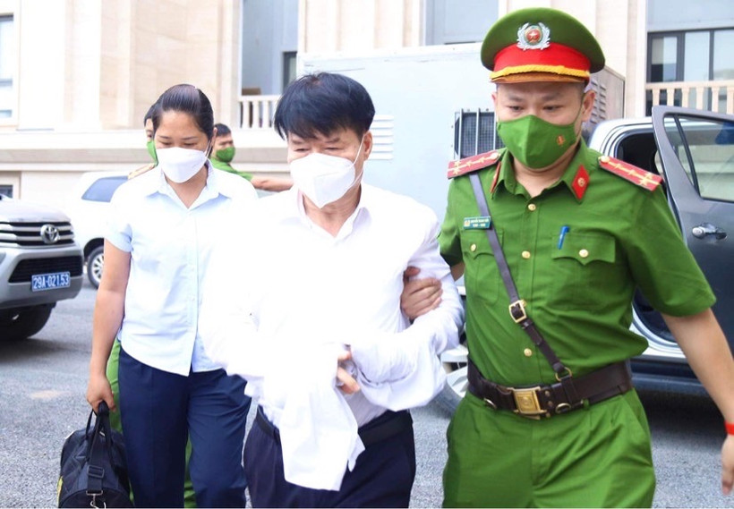 Lực lượng chức năng dẫn giải bị cáo Trương Quốc Cường tới khu vực xét xử. 